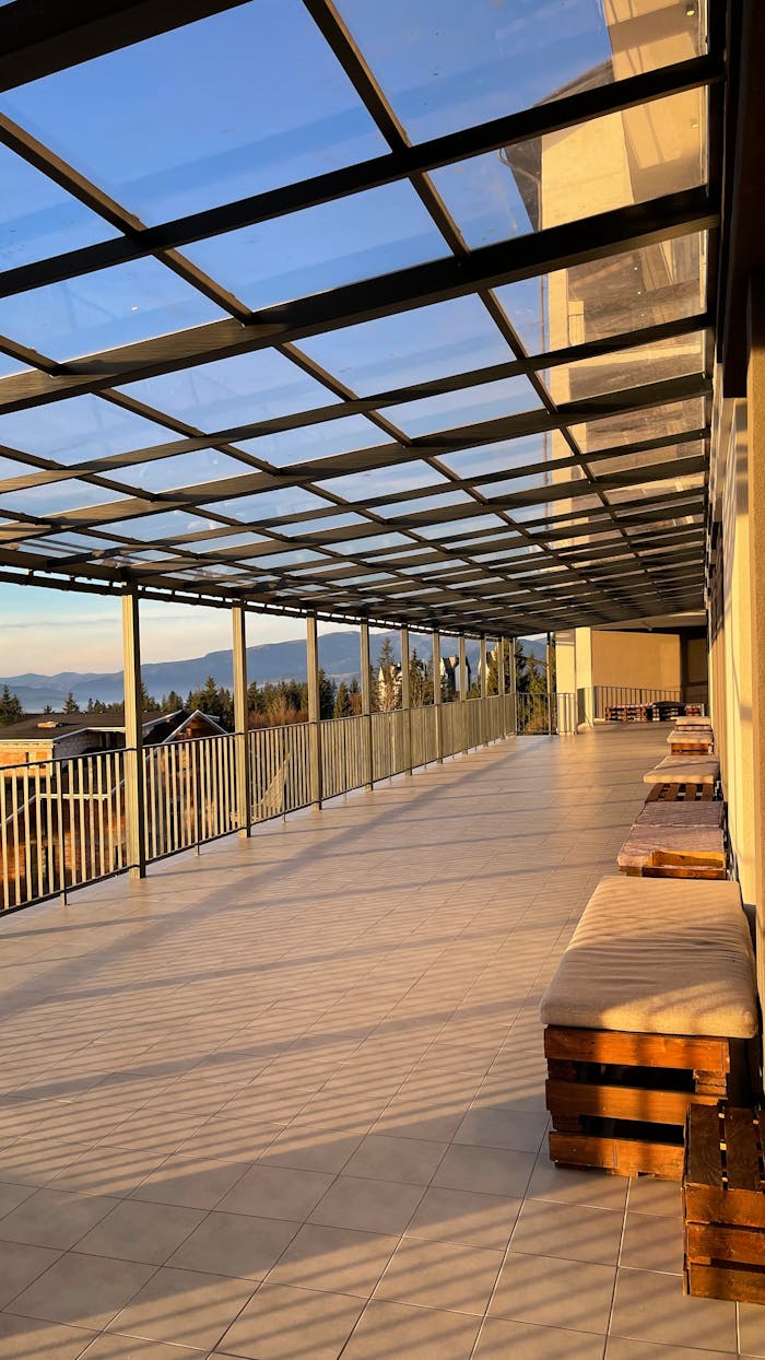 Spacious terrace in Yaremche, Ukraine, with a glass roof and benches, offering scenic mountain views.